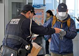 　ＪＲ天竜川駅で利用者に事件の概要が書かれたチラシ入りティッシュを手渡す警察官＝２７日午前、浜松市
