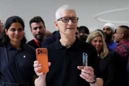 　右手にアイフォーン１７プロを持つアップルのクックＣＥＯ＝９月９日、米カリフォルニア州（ロイター＝共同）