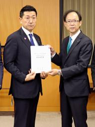 　赤間二郎防災担当相（左）に要望書を手渡す大分県の佐藤樹一郎知事＝２７日午後、内閣府