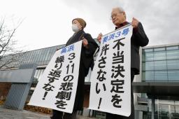 　関西電力美浜原発３号機と高浜１〜４号機の運転差し止めを求めた仮処分の即時抗告審で、申し立てが退けられ「不当決定」などと書いた紙を掲げる原告ら＝２８日午前、名古屋高裁金沢支部前
