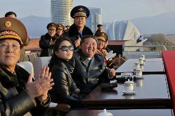 　空軍の記念日を前に、北朝鮮東部元山の葛麻飛行場で開かれた式典に参加した金正恩朝鮮労働党総書記（手前左から３人目）。左隣は娘。３０日付の労働新聞が掲載した（コリアメディア提供・共同）