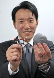 　小惑星ベンヌ（右）とリボースの模型を手にする東北大の古川善博准教授＝１日、東京都千代田区