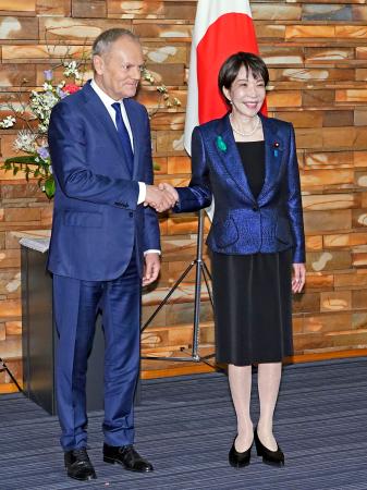 　首脳会談を前に握手を交わすポーランドのトゥスク首相（左）と高市首相＝１５日午前、首相官邸