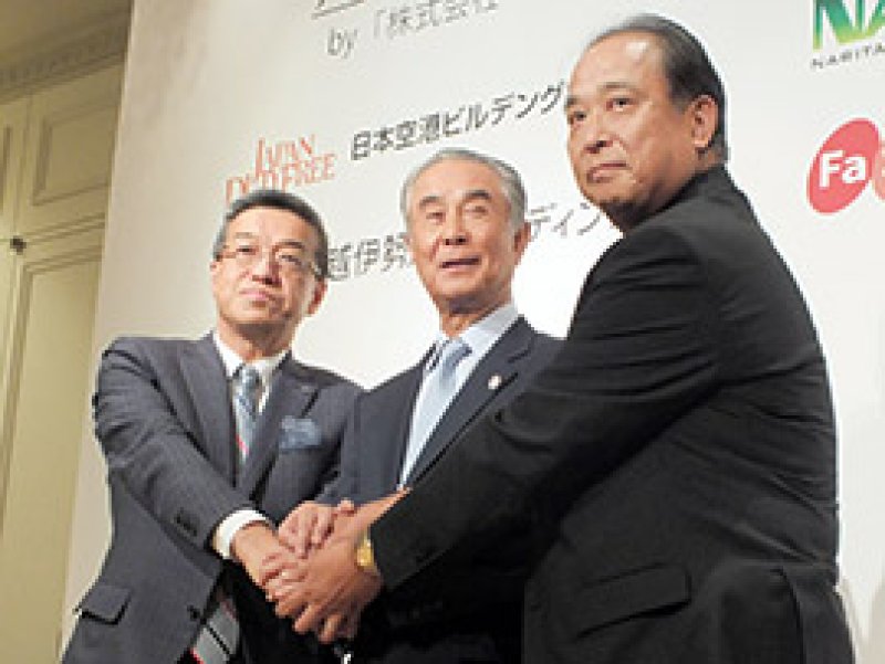 記者会見後に握手を交わすＮＡＡリテイリングの蒲生社長（右）と日本空港ビルディングの鷹城勲社長（中央）、三越伊勢丹ホールディングスの大西洋社長＝３１日、東京都内のホテル