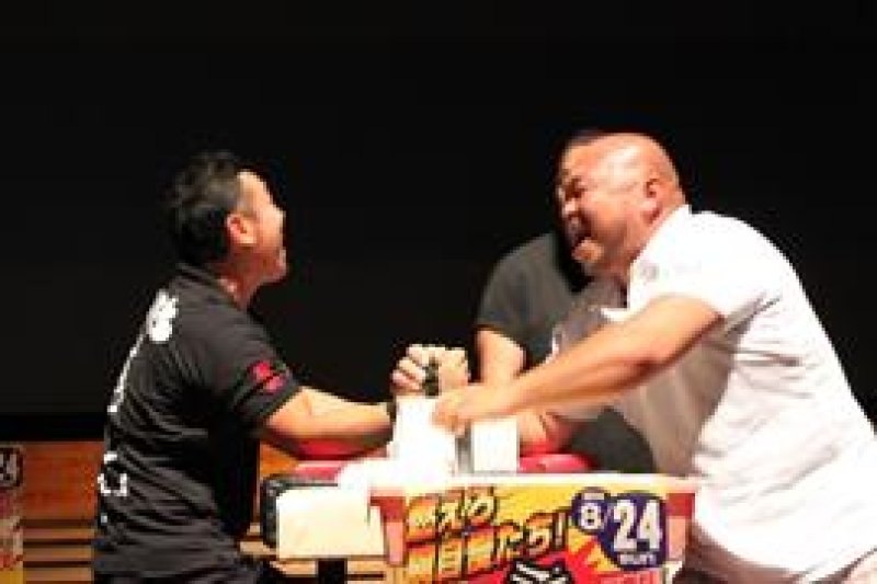 力自慢が豪腕ナンバーワンを競ったアームレスリング大会。８０キロ超決勝を戦った森下さん（右）と渡辺さん＝２４日、南房総市白浜町
