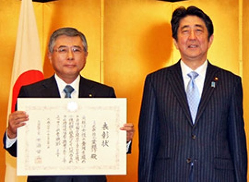 安倍首相から表彰状を受け取った千葉銀の佐久間英利頭取（左）＝１２月、首相官邸