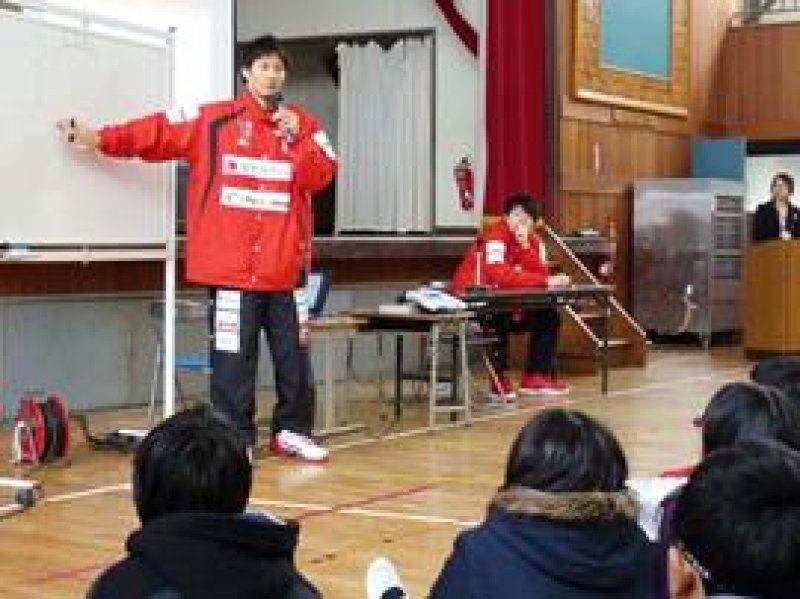 児童にお金の仕組みを解説する岡田選手（左）＝松戸市の市立河原塚小学校