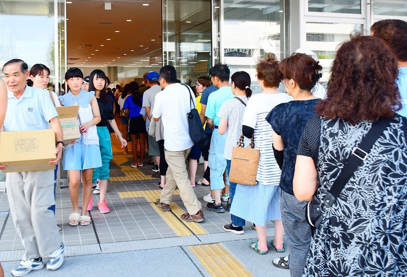 水と非常食の配給に並ぶ市民＝１０日午後、市原市役所