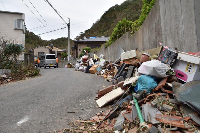 強風で吹き飛んだがれきや家具が散乱する町内＝１２日午後１時４０分、鋸南町岩井袋