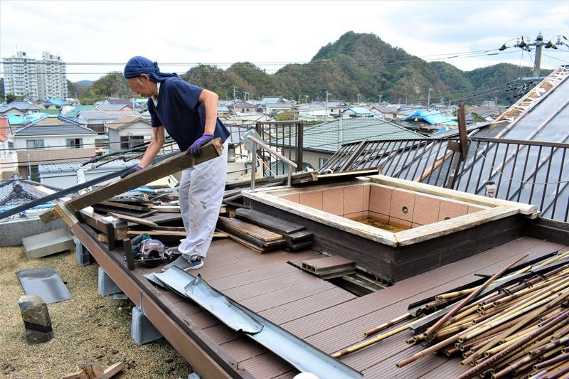 台風１５号により被災した露天風呂の修復作業を行う業者＝１３日午後１時５５分ごろ、鋸南町