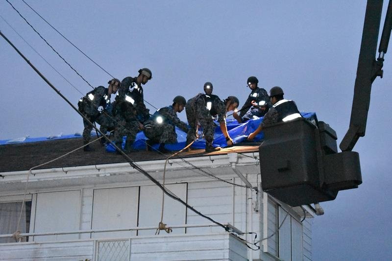竜巻で被害を受けた住宅の屋根にブルーシートを張る自衛隊員＝１７日午後５時１５分ごろ、市原市永吉