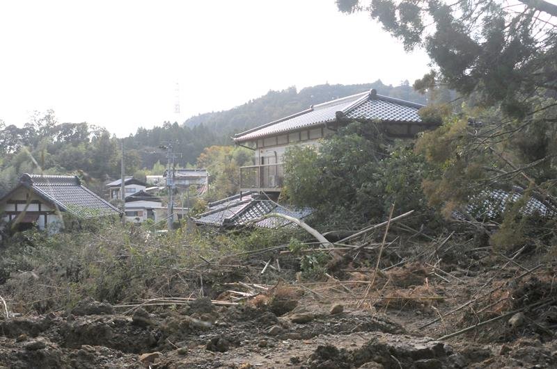 裏山の土砂が押し寄せ１階部分が埋もれた家＝３１日午後１時３５分ごろ、大網白里市