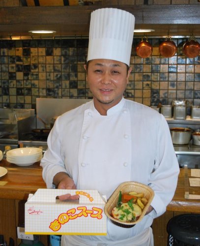 持ち帰り用のきのこスープとハンバーグを手にする井尻店長＝八千代市
