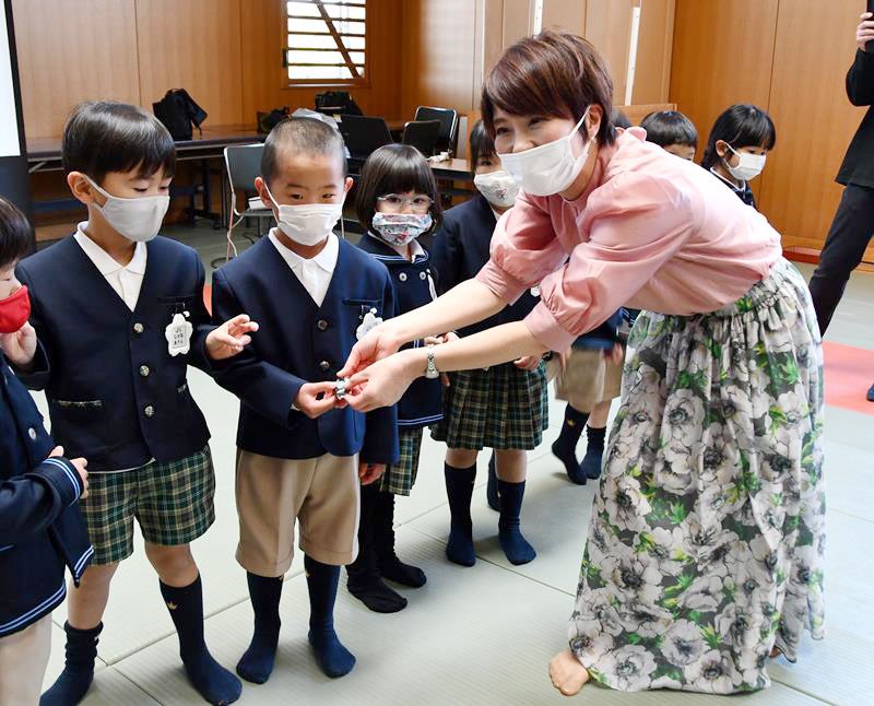 園児に交通安全のアサガオの種を手渡す高田さん（右）＝柏市