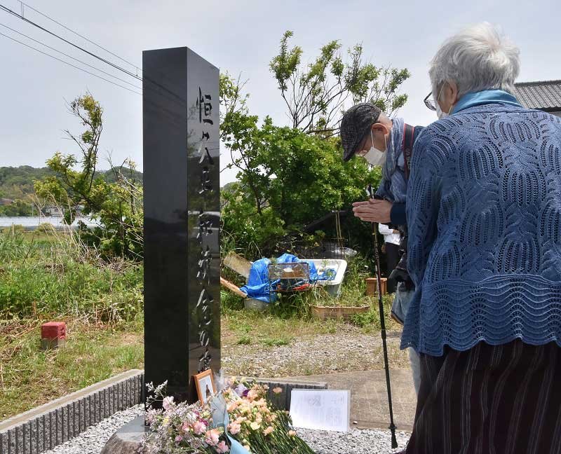 犠牲者を悼み、恒久平和祈念の碑前で献花する参加者＝８日、鋸南町下佐久間