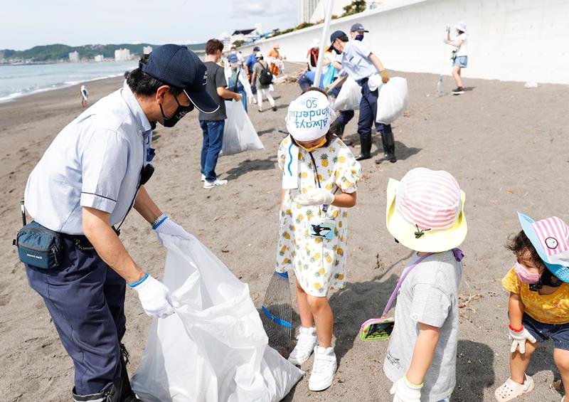 東条海岸でごみを拾い集める子どもたち（鴨川シーワールド提供）
