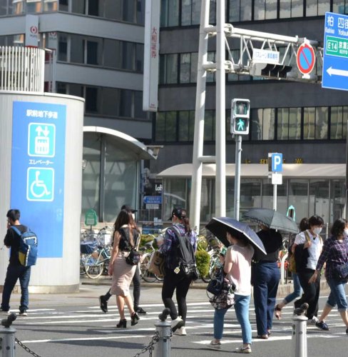 強い暑さの中、千葉駅前を歩く人たち＝２２日午後、千葉市中央区