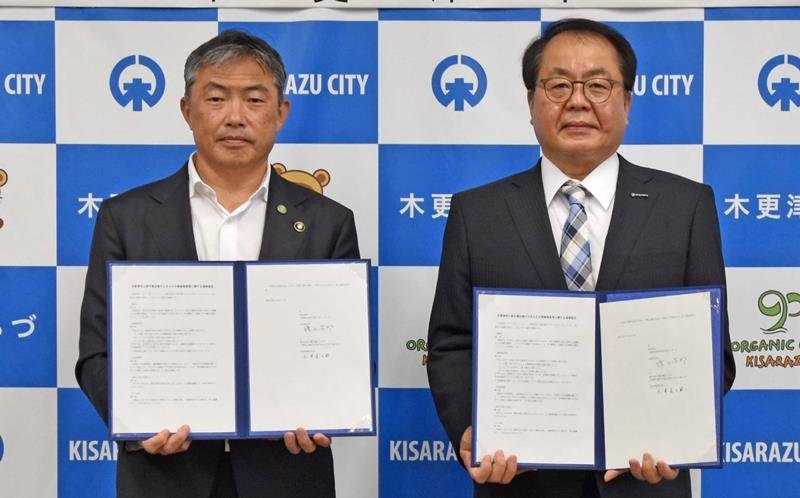 協定書を手にする渡辺市長（左）と大澤社長＝１２日、木更津市役所