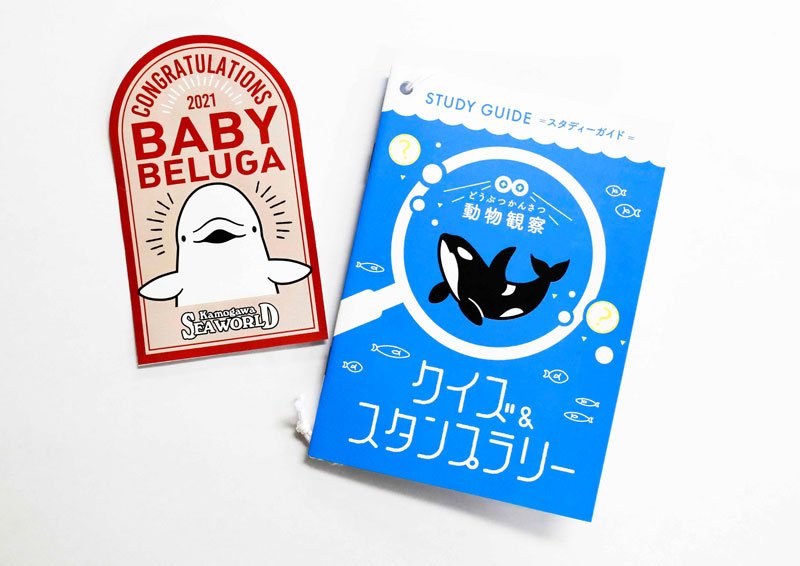 「家族月間」の特別割引を利用すると贈られるスタンプラリーノート（右）とベビーベルーガ誕生記念ステッカー（鴨川シーワールド提供）
