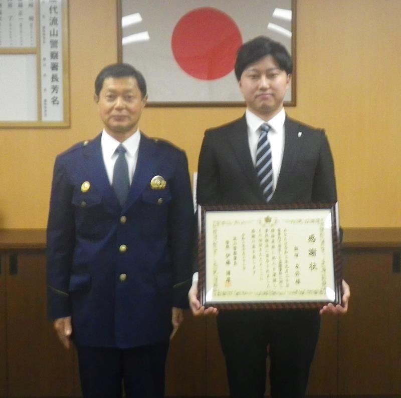 伊藤博厚署長（左）から感謝状を受け取った飯塚さん（流山署提供）
