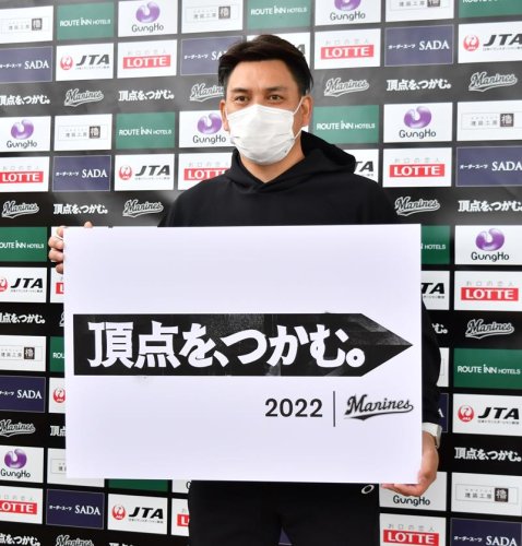 今季のスローガンが書かれたボードを手にする千葉ロッテ・井口監督＝沖縄県石垣市
