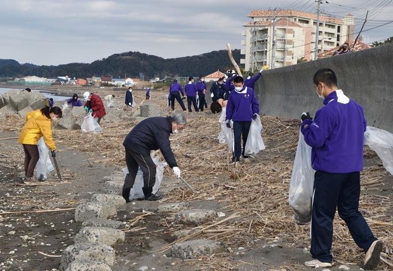 地元住民と協力して海岸のごみを拾う安房高の野球部員ら＝館山市
