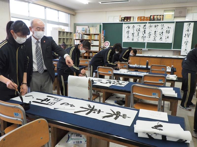 辻元さん（左から２人目）から指導を受ける袖ケ浦高書道部員＝袖ケ浦市
