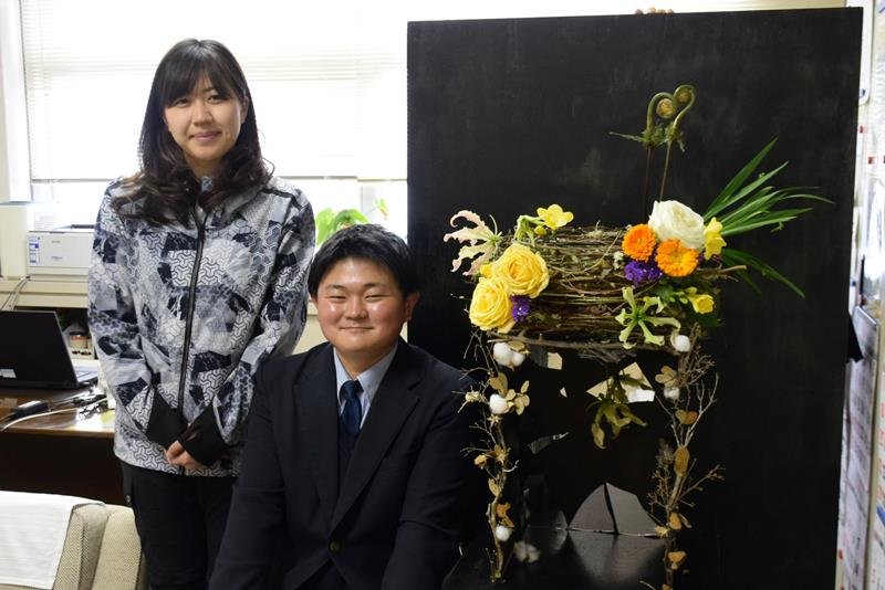 受賞作を再現したフラワーアレンジメントの隣で笑顔を見せる金子さん（右）。左は大山教諭＝旭市
