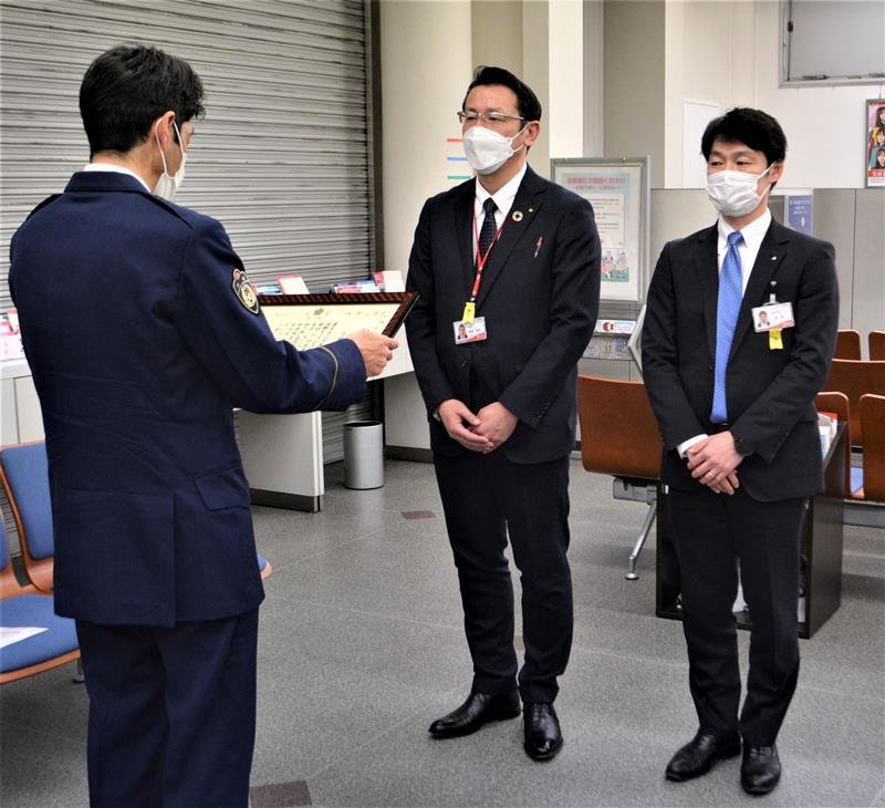 飯島署長（左）から感謝状を受け取る飯島智和支店長（中央）と土屋支店長代理＝八千代市の千葉銀大和田支店
