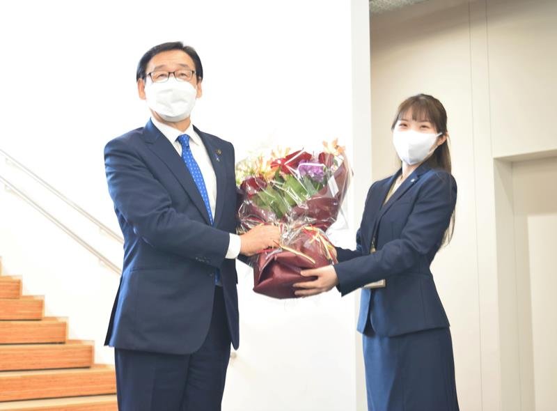 市川市役所に初登庁し職員から花束を受け取る田中市長（左）＝２２日、市川市
