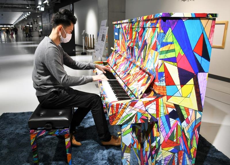 成田空港の第３ターミナルに設置されたストリートピアノで演奏する空港スタッフの高橋さん＝成田市
