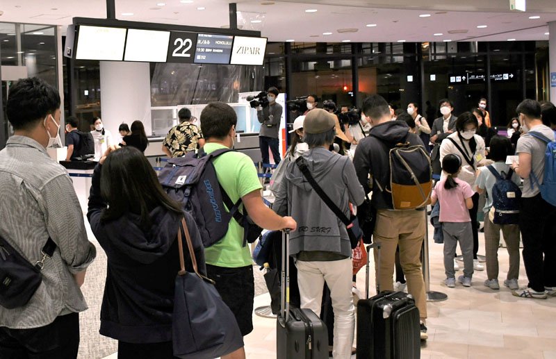 ＬＣＣが運航するホノルル線の搭乗ゲートに並ぶ旅客＝２８日夜、成田空港第１ターミナル
