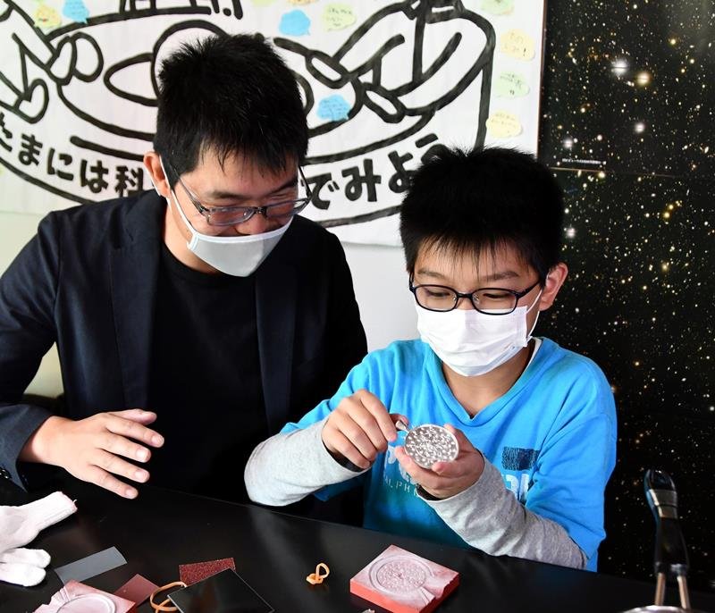 鋳型から鏡の元となる合金を取り出す参加者の親子＝柏市
