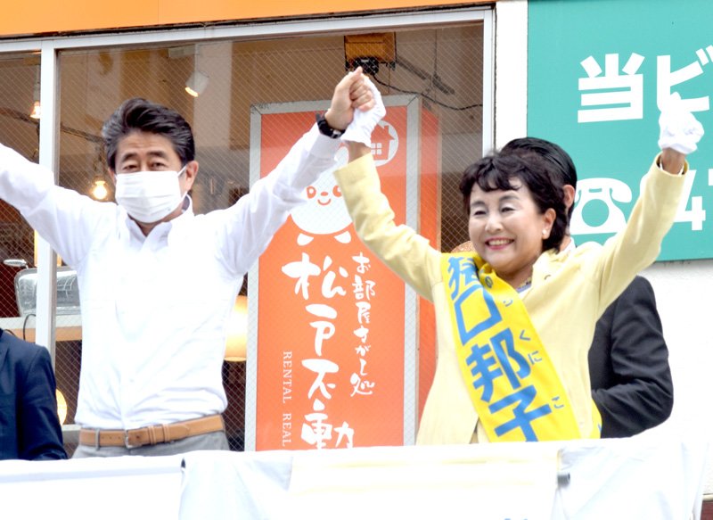 演説終了後、安倍元首相（中央）と手をつなぎ、アピールする猪口氏＝３日、ＪＲ松戸駅前