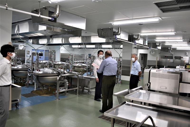 完成した学校給食センター東八千代調理場の内部を視察する服部市長（中央奥）ら＝２９日、八千代市