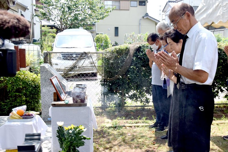 正午に合わせ黙とうする慰霊祭実行委長の塚本さん（手前）や市民＝１５日、銚子市