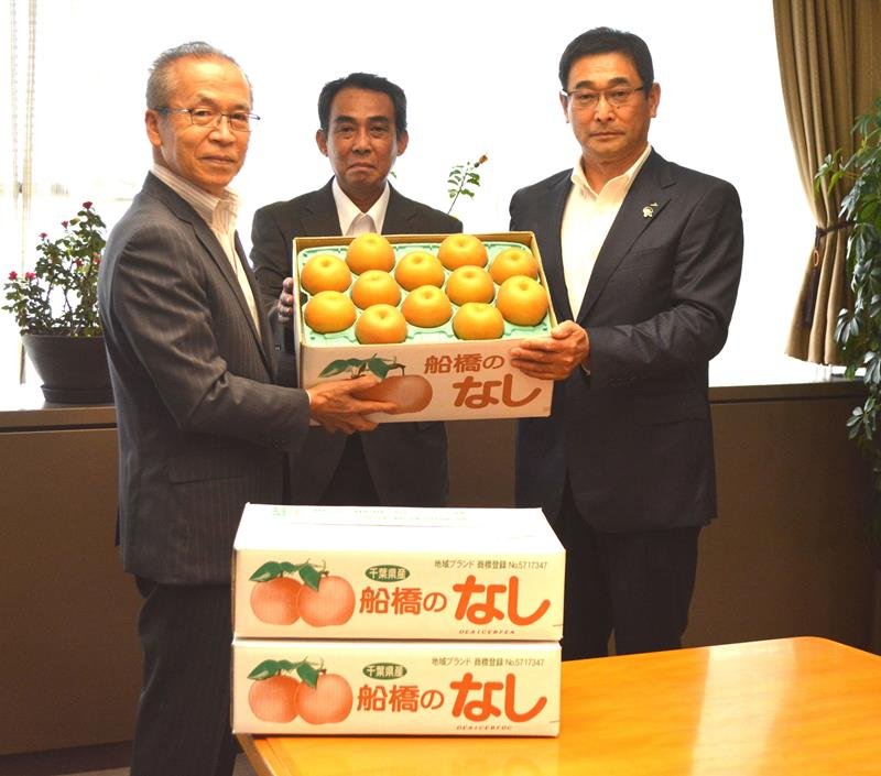 福祉施設に寄贈する船橋産の梨を市長に託した石橋組合長（中央）と時田代表理事組合長（右）＝船橋市役所
