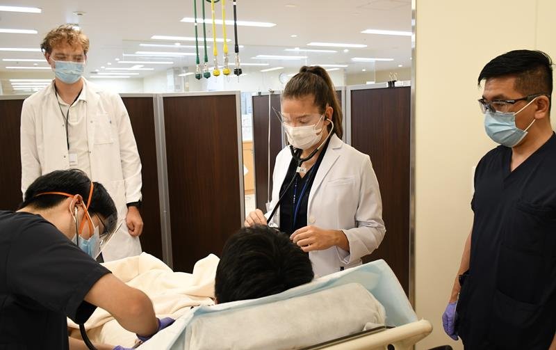 国際医療福祉大学成田病院の救急科で実習するドビルさん（右から２人目）とヨナスさん（左奥）＝成田市

