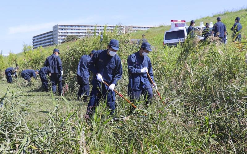 江戸川河川敷で捜索にあたる県警の捜査員＝９月２８日、流山市（共同）
