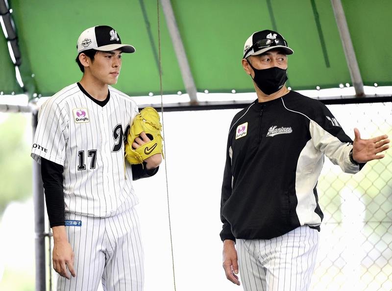 昨年の春季キャンプで千葉ロッテ・佐々木朗（左）と話をする吉井氏＝昨年２月、石垣（代表撮影）
