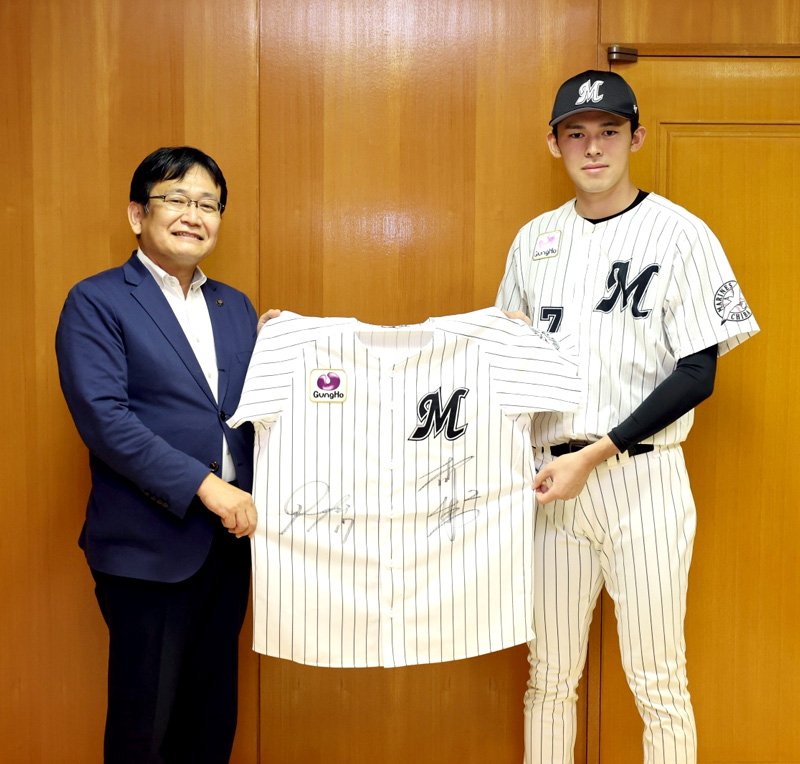 千葉ロッテマリーンズの佐々木投手（右）からサイン入りユニホームの寄贈を受ける神谷市長（千葉市提供）
