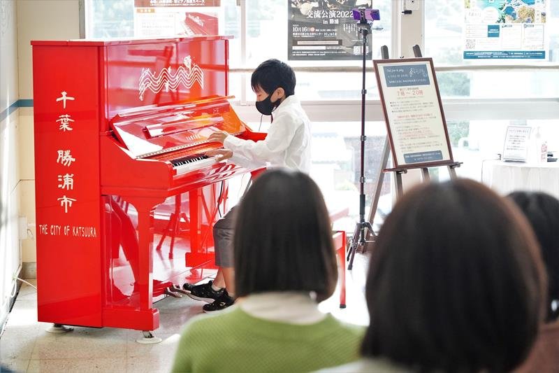 駅ピアノで演奏を披露する下村君＝１５日、ＪＲ勝浦駅