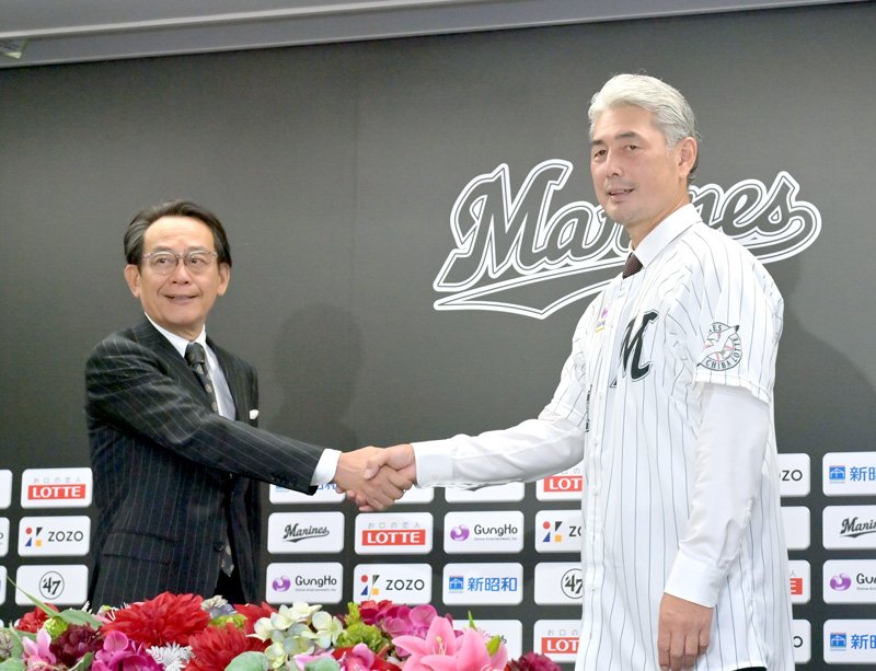 会見を終え握手を交わす千葉ロッテの河合オーナー代行（左）と吉井監督＝ＺＯＺＯマリン