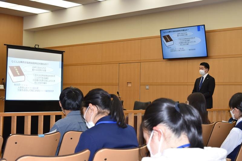 裁判員裁判の制度について説明する裁判官。学生はメモを取りながら話を聞いていた＝２０日午後、千葉地裁
