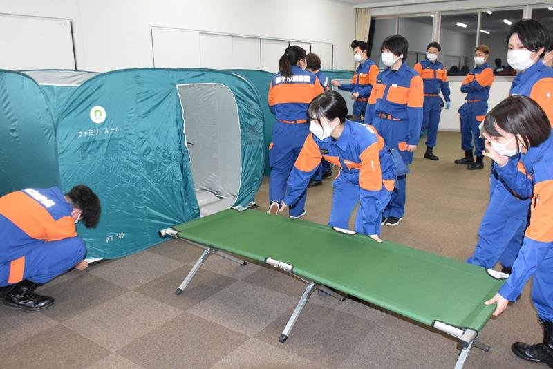 避難所で使うパーティションなどを組み立てる学生消防団員ら＝銚子市
