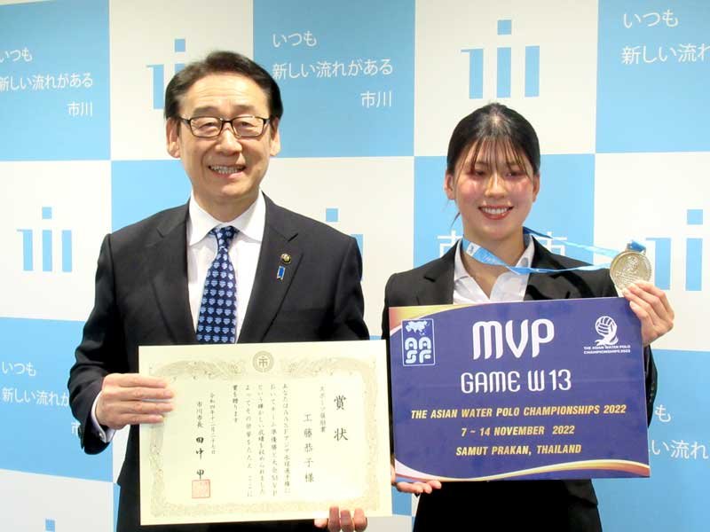 アジア水球選手権の銀メダルを手にする工藤恭子さん（右）。左は田中市長＝市川市役所