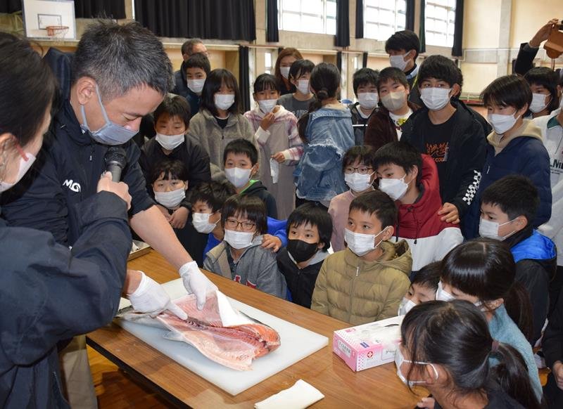 児童の前でサーモンをさばく星嶋さん＝１７日、睦沢小
