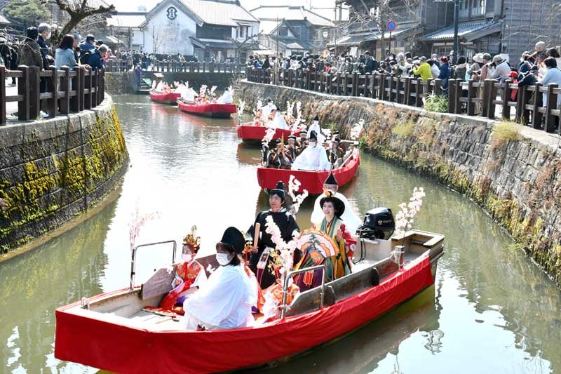 華やかなひな人形姿で小野川をパレードする一行＝昨年３月、香取市