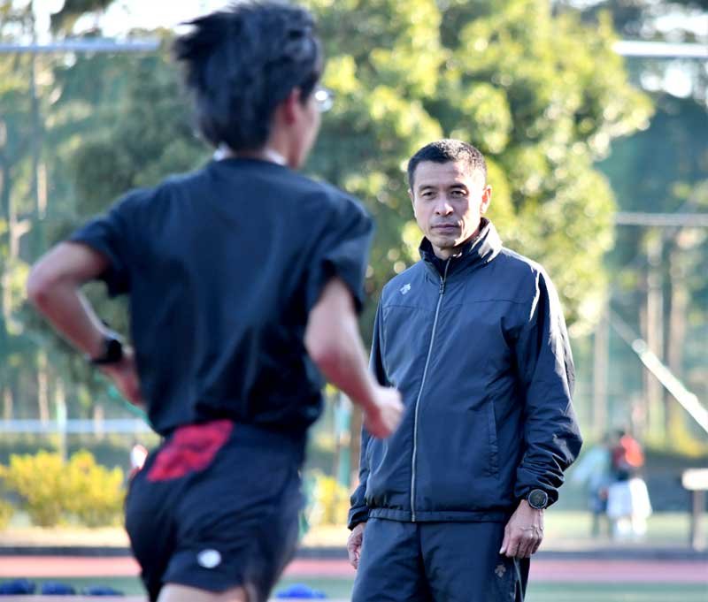 練習を見守る八千代松陰高陸上部長距離の大塚正人前監督＝昨年１２月、八千代市