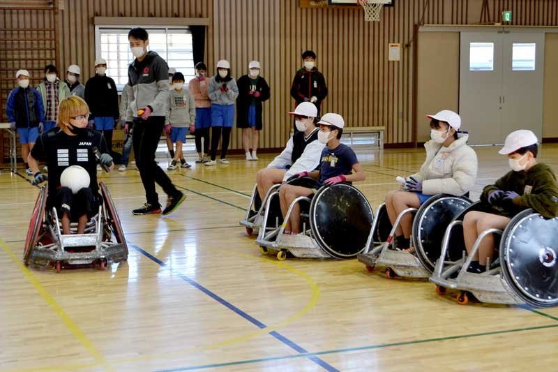 競技用車いすの操作やタックルの方法をレクチャーする池崎選手（左）＝２６日、千葉市花見川区の市立畑小
